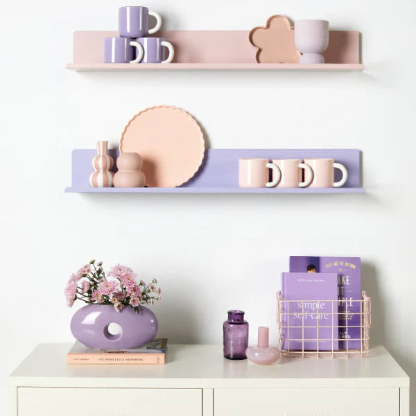 Decorative shelves with pastel-colored items on a white wall