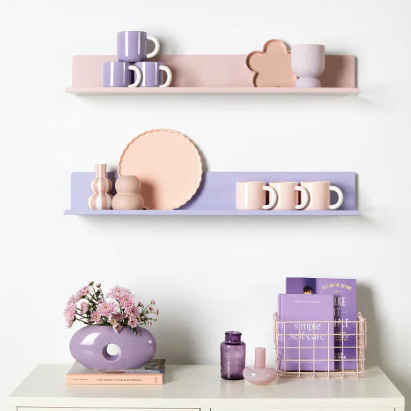Decorative shelves with pastel-colored items on a white wall