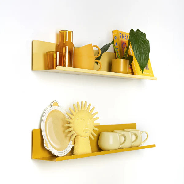 Yellow kitchenware on shelves against a white wall