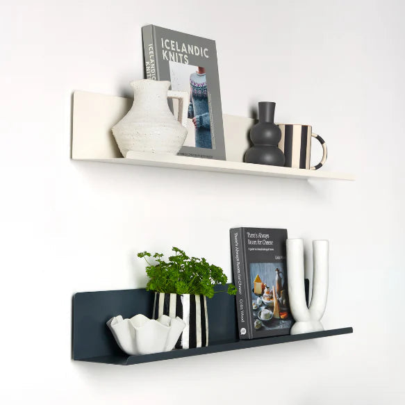 Decorative shelves with books, vases, and plants against a white wall