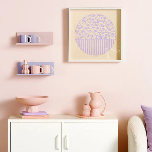 Lilac shelf on wall with light purple and pink decor and cabinet
