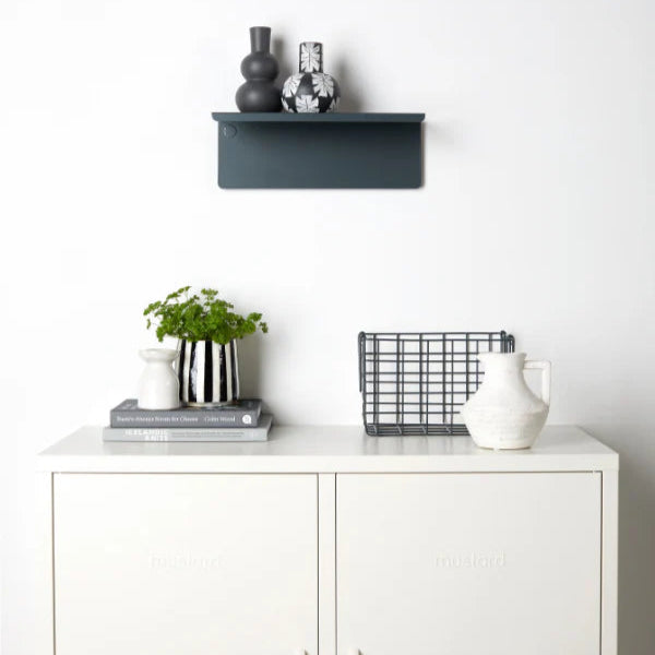 White cabinet with decorative items including a plant, vases, and a basket on a white background