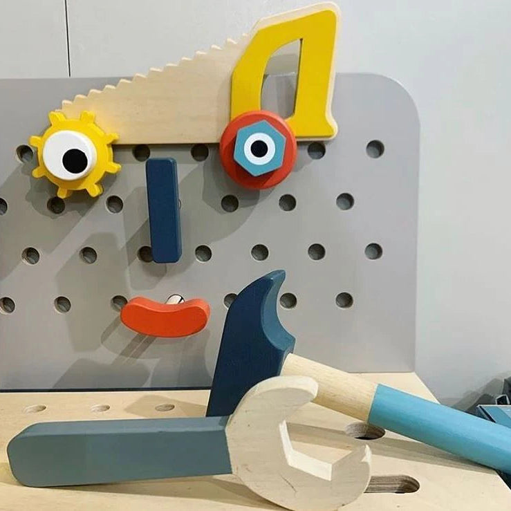 Toy tool set with colorful handles on a pegboard background