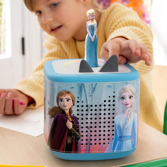 Child playing with a toy pencil sharpener featuring characters from Frozen.