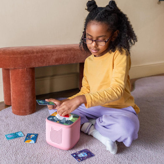 Child playing with a pink toy on the floor