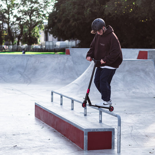 Person on a scooter at a skate park with a helmet