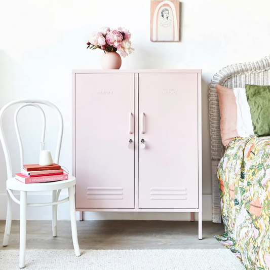 Pink cabinet in a room with a chair and bed