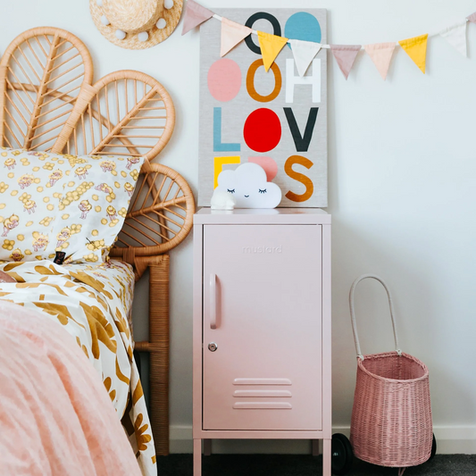 Children's room with a pink locker, floral bedspread, and colorful 'LOVE' wall art.