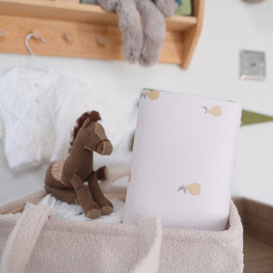 Children's room with wooden shelf, plush toys, and a white pillow with a horse design.