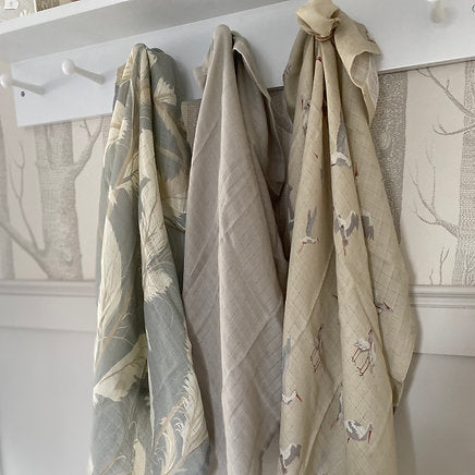 Three fabric swatches hanging on a rack with a neutral background
