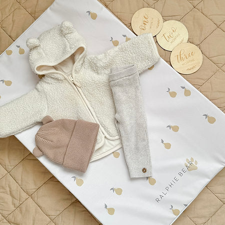 Baby clothing set with jackets, hats, and pants on a branded blanket.