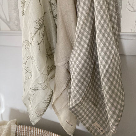 Three fabric swatches hanging on a rack with different patterns and textures.