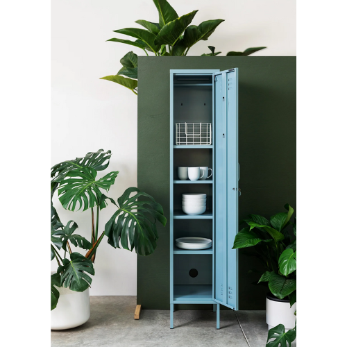 Green cabinet with open doors displaying kitchenware, surrounded by potted plants.
