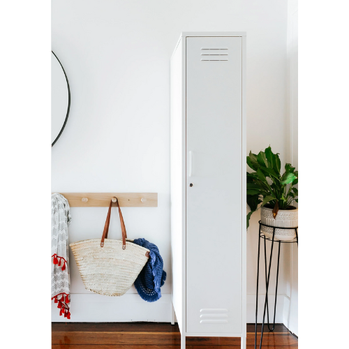 White locker with a bag and jacket on a wooden bench against a white wall.