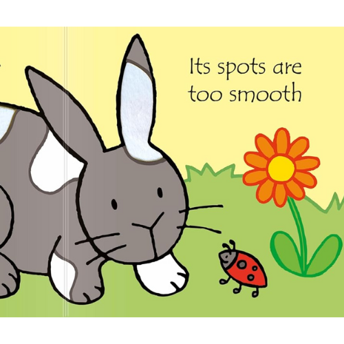 Illustration of a rabbit, ladybug, and flower on a book page with text.