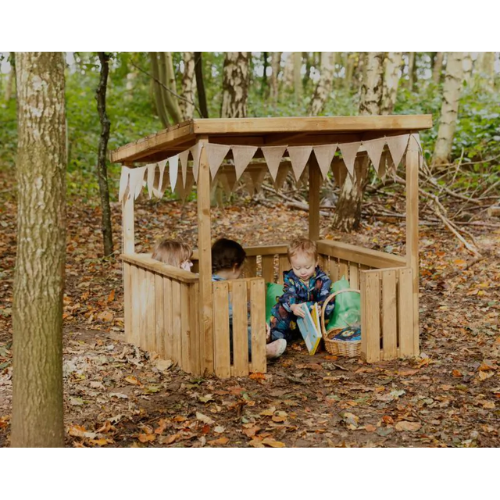 Children playing inside a wooden playhouse in a forest setting