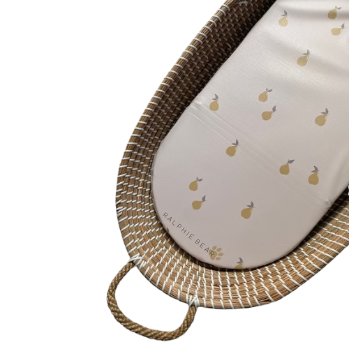 Wicker basket with a white cushion featuring yellow fruit patterns on a white background