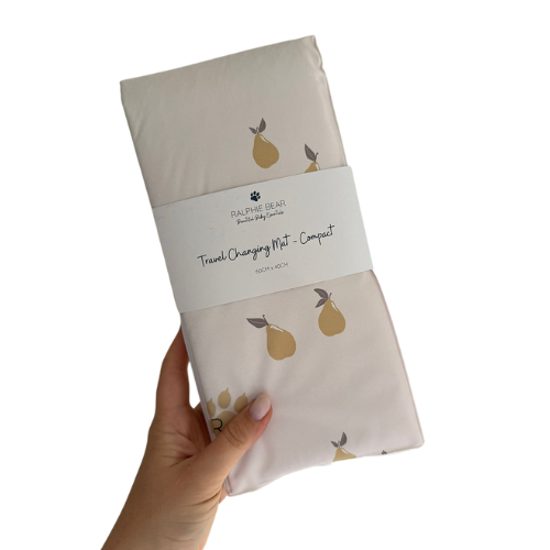Folded baby changing mat with pear pattern held by a hand on a white background