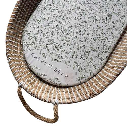 Baby changing mat with leaf pattern on a woven bag, featuring the brand 'Ralphie Bear'.
