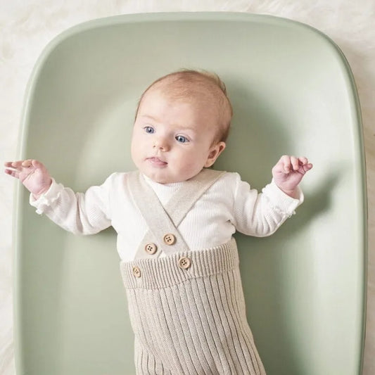 Baby on a green changing pad