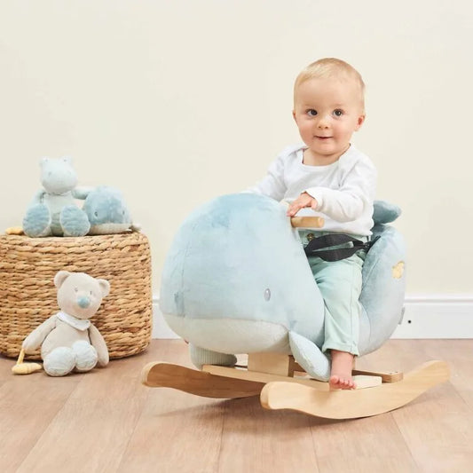 Baby sitting on a rocking toy with plush toys in the background