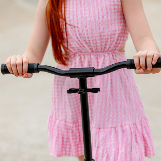 Person holding a scooter with a plain background