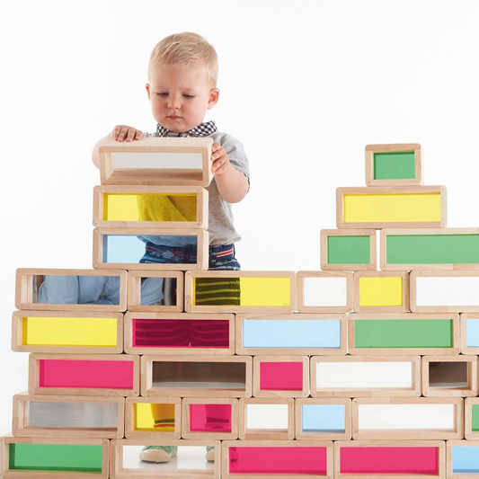 Child playing with colourful building blocks on a white background