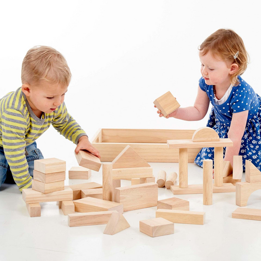 Two children playing with wooden building blocks on a white background