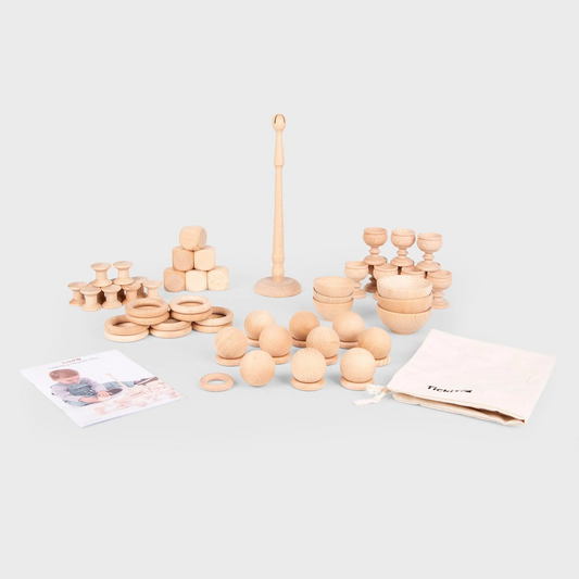 Set of wooden toys including rings and cups on a light gray background