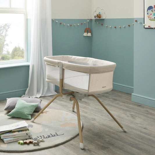Baby crib in a room with light blue walls, wooden floor, and toys on the floor.