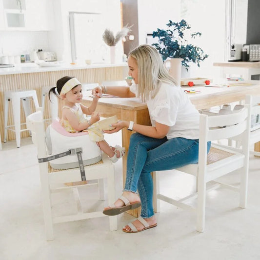 Woman and child sitting at a table in a bright, modern kitchen.