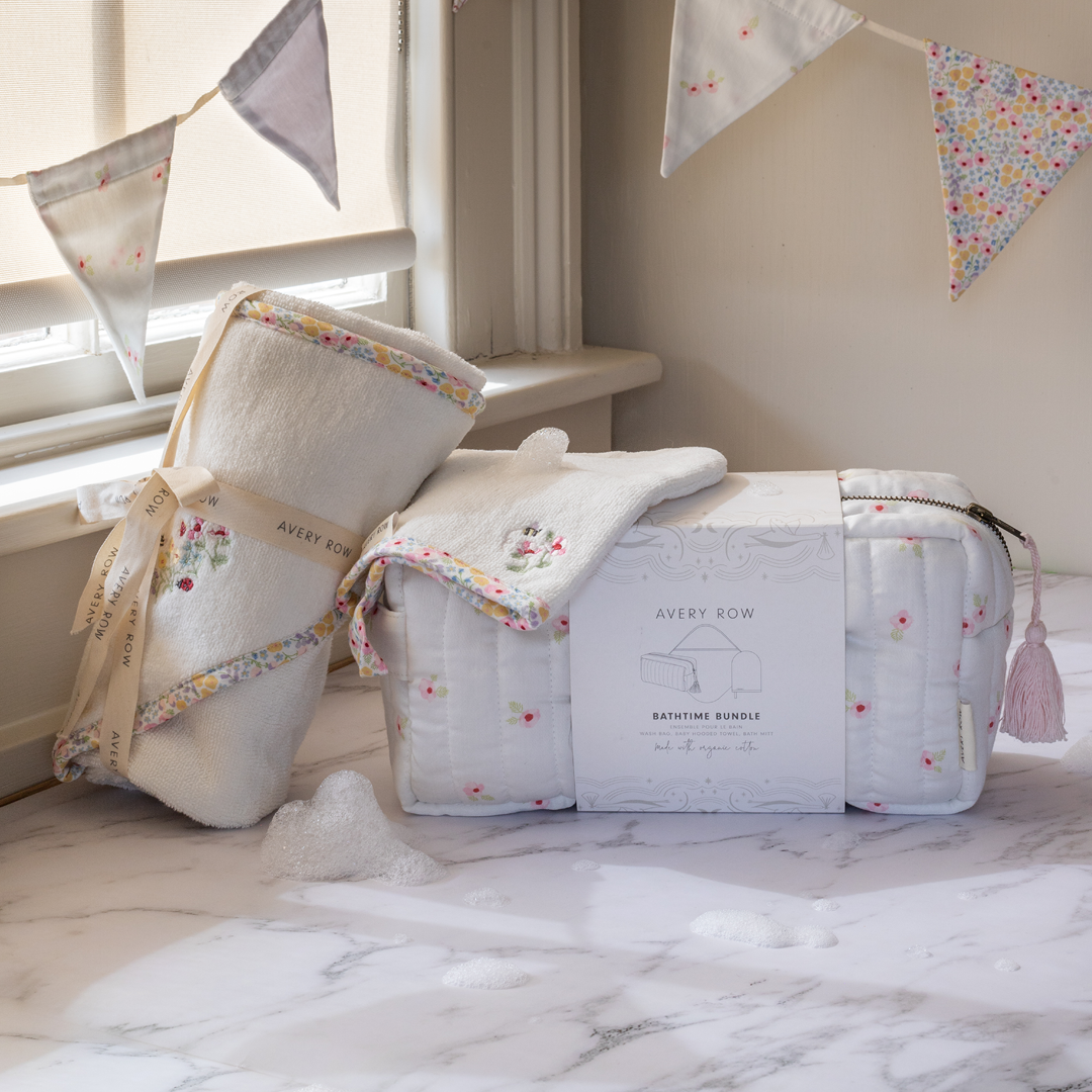 Baby bath time bundle with towels and a bag on a marble surface, decorated with bunting.