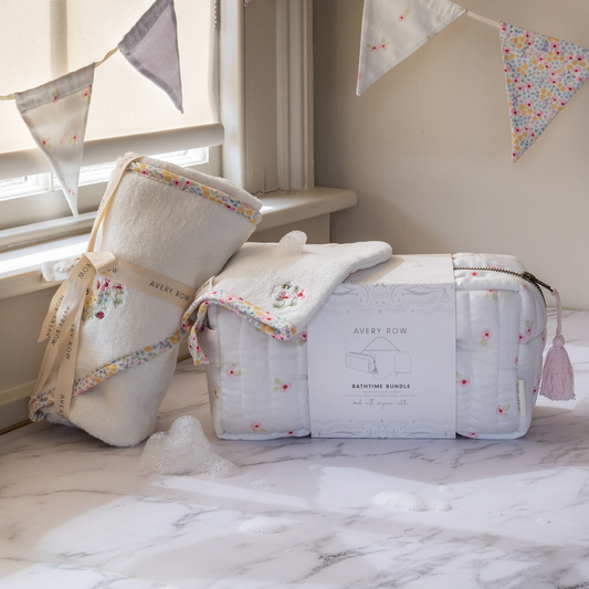 Baby bath time bundle with towels and a bag on a marble surface, decorated with bunting.