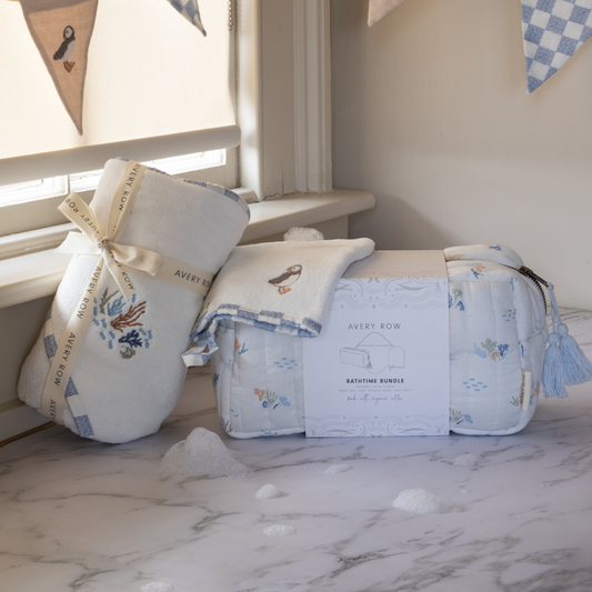 Baby gift set with blankets and a bag on a marble surface