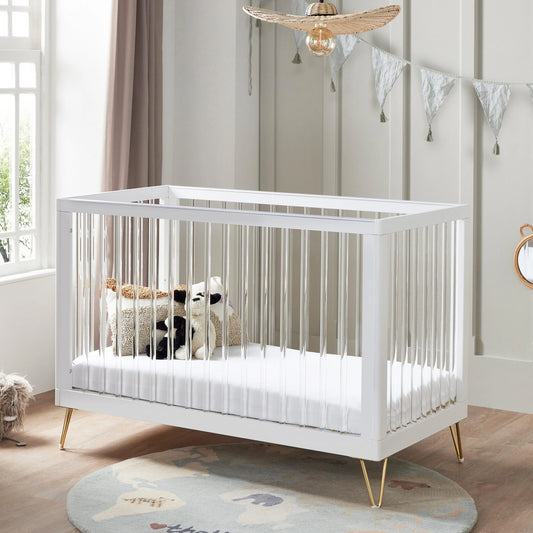 White crib with stuffed animals in a nursery setting