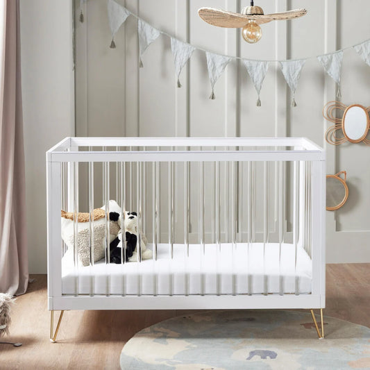 White crib in a nursery with decorative elements