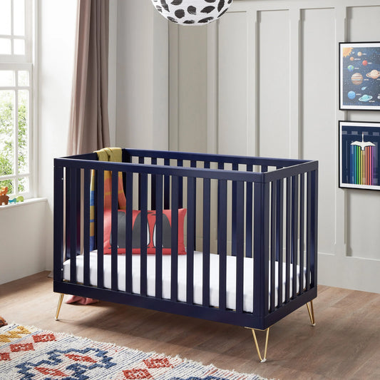 Navy crib with gold legs in a nursery setting with colorful decor