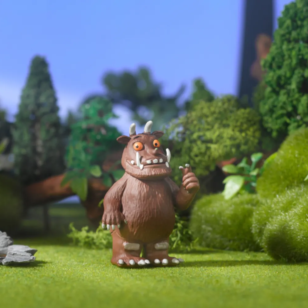 Toy figure of a brown creature with a forest background