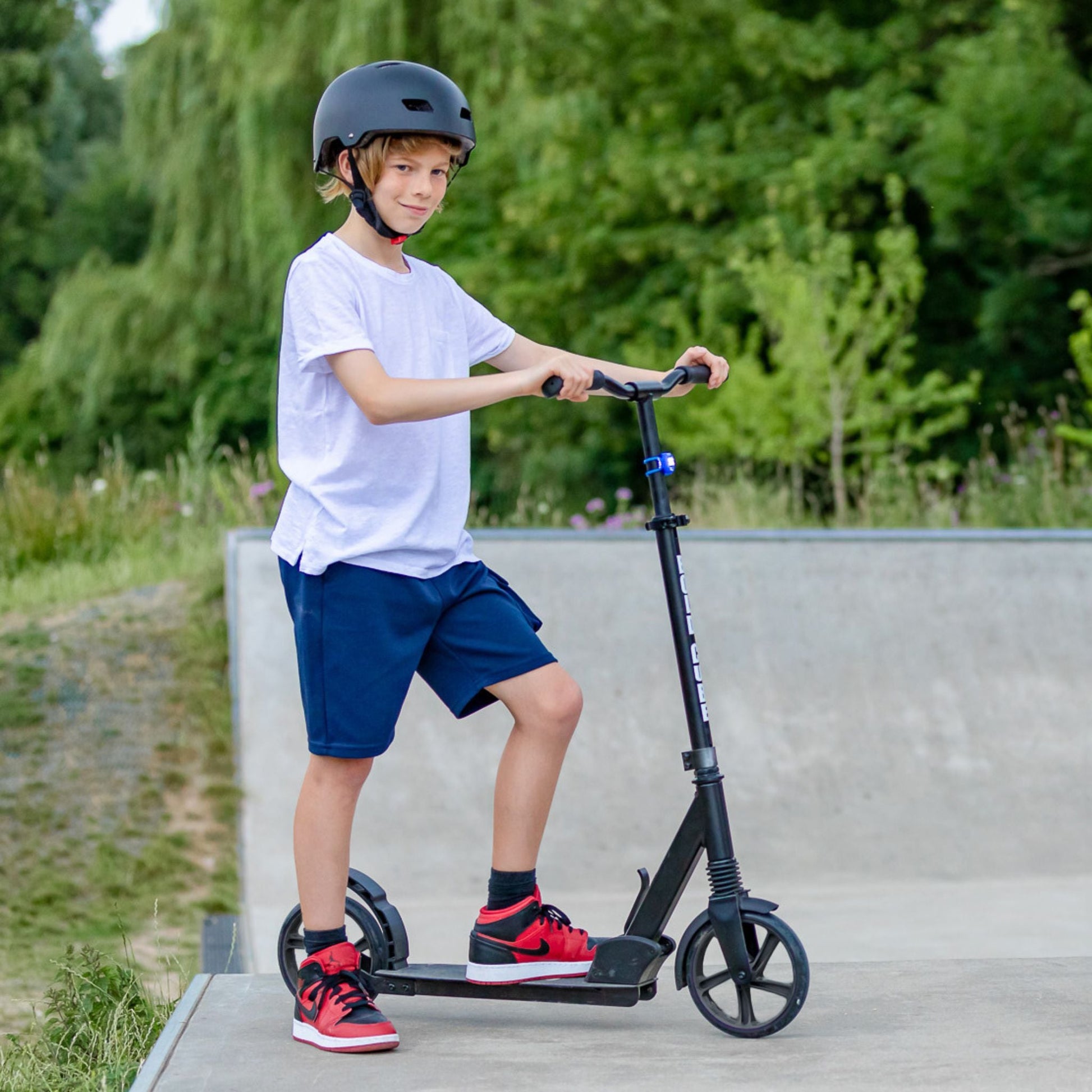 Child riding a scooter with a helmet in an outdoor setting