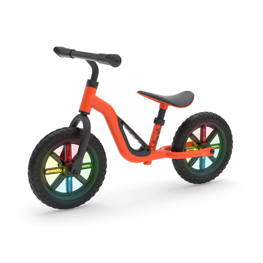 Orange balance bike with colorful wheels on a white background