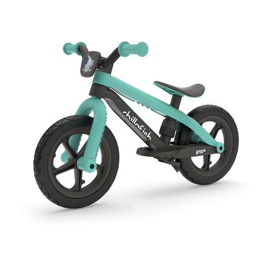 Turquoise and black balance bike on a white background