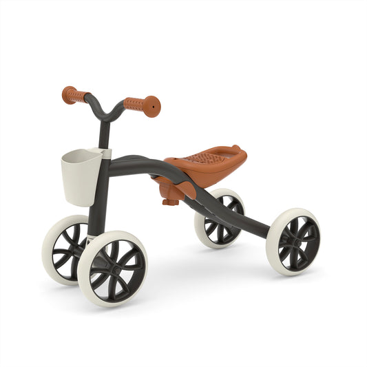 Children's tricycle with brown seat and white wheels on a white background