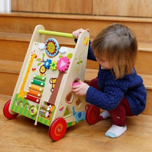 Child playing with a colorful wooden toy on a wooden floor.