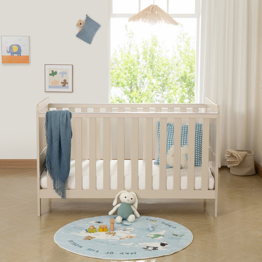 Nursery room with a cot, teddy bear, and round rug featuring animals.