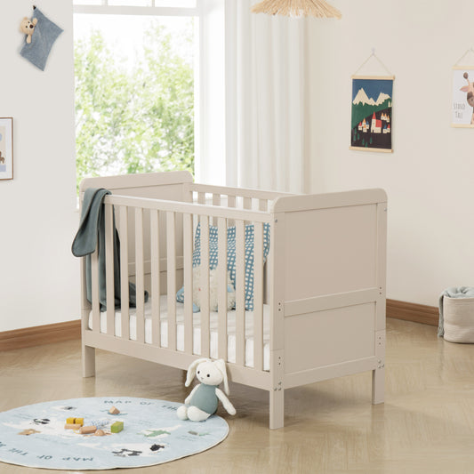 Cashmere Cot in a bright nursery with toys and a rug on the floor.