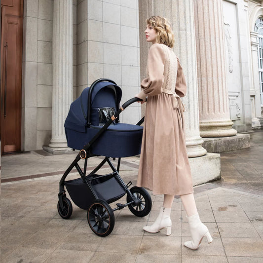 Woman pushing a navy blue stroller in an urban setting with classical architecture.