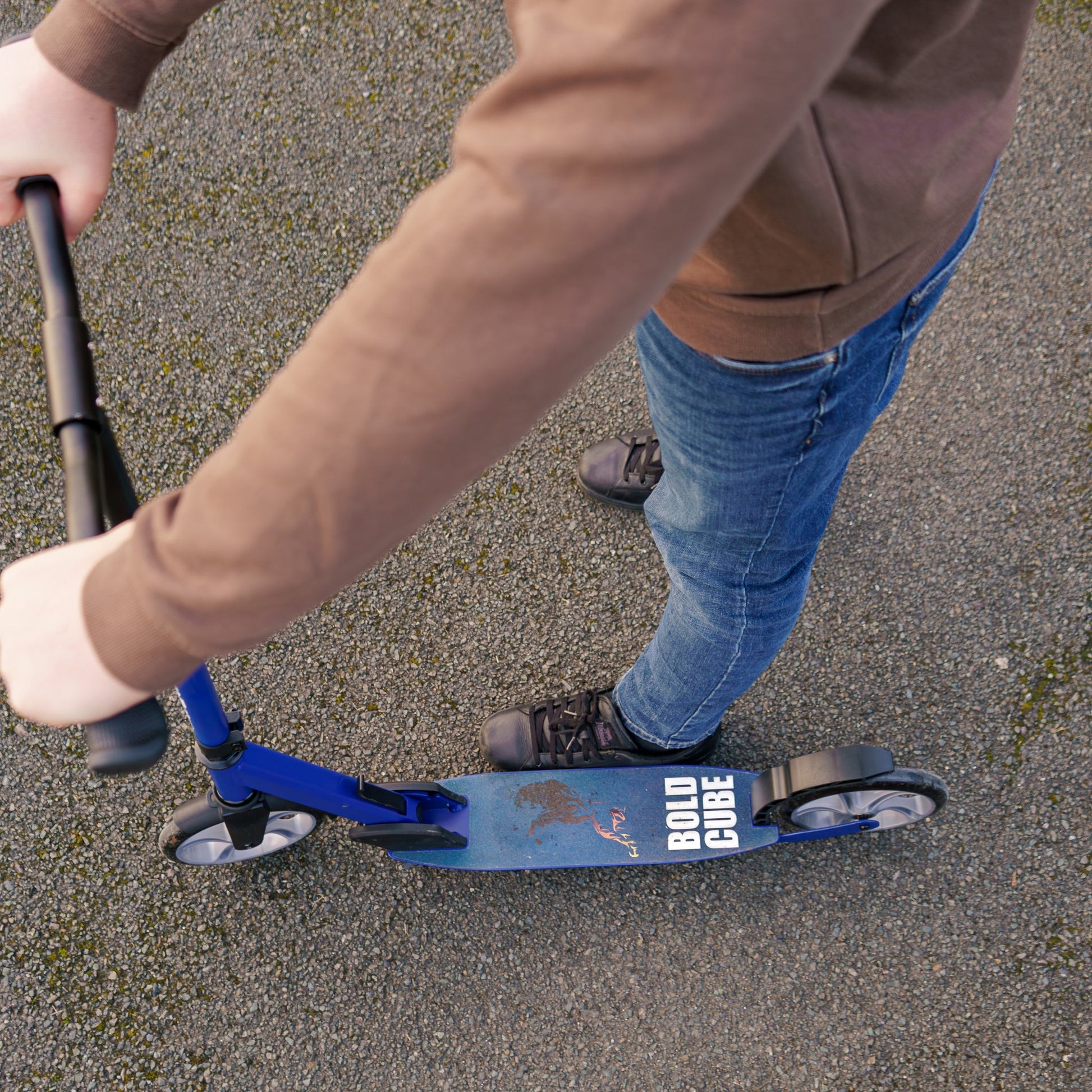 Person riding a blue scooter on a paved surface