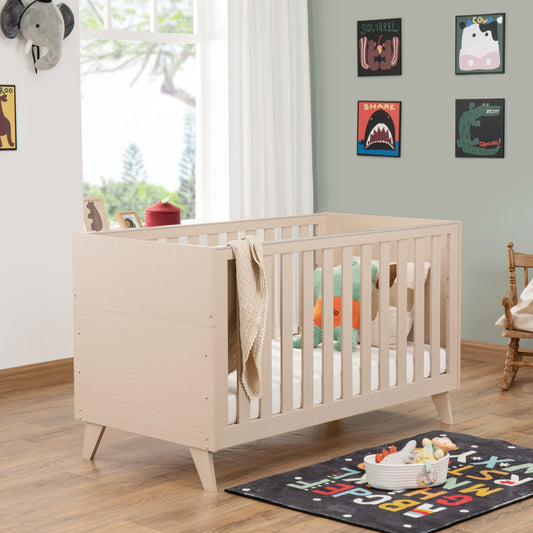 Wooden cot in a child's room with toys and decor