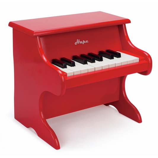 Red toy piano with black and white keys on a white background