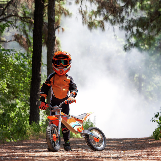 Child on an orange balance bike with smoke effect in a forest setting